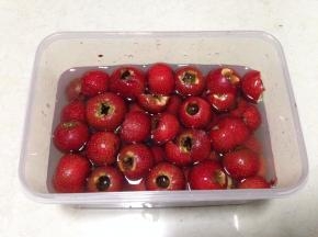 把山楂放入清水中，放入一勺盐，泡15分钟（盐有固色的作用）后捞出备用