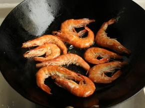 炒锅烧热，放入色拉油，一定要热锅冷油，既能激发出食材的香味又不会破坏油脂中的营养成分。把虾放入锅中煎到两面酥脆，捞出待用。