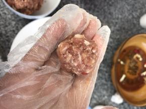 用手逐个挤成直径约2.5厘米的小肉丸
