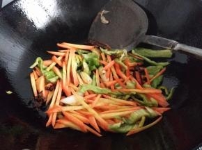 热锅入油放入胡萝卜青椒丝翻炒