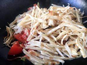 再放入大饼丝，盖上锅盖儿，中火，焖1分钟。锅底的蔬菜散出的热气将大饼丝焖软。