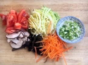 将圆白菜切丝，胡萝卜切丝，木耳切丝，香菇切丝，西红柿切块，小香葱切成葱花。