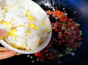加入提前放蒸笼煲蒸好的玉米粒饭，翻炒均匀