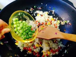 陆续加入豌豆粒，再次翻炒均匀，