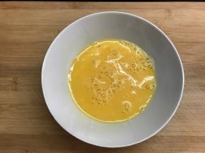 鸡蛋打入碗中。加少许料酒打散。