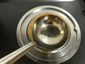 取一不锈钢勺子，均匀地刷上少许食用油，放炉上烧热。