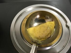 等蛋皮四周微微翘起，用筷子夹起一边折向另一边，轻轻地按压下封口。