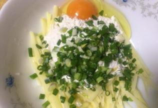 土豆去皮切细（手工切滴，刀工还算过得去吧）放入切了的葱花，土豆丝装入碗里打入鸡蛋放面粉