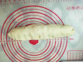 借助刮板,将面团整成长条状。