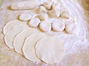 醒好的面团搓成长条，揪成小剂子，压扁，擀成中间厚边缘薄的面皮