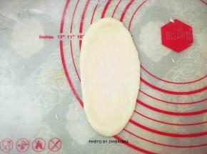 取一个松弛好的面团，擀成椭圆形，用手拍掉两侧气泡。