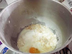 将除黄油以外的所有材料放入厨师机打面桶，先低速混合成团，再转中速揉至面团能拉出厚膜的状态，加入软化的黄油，继续揉至完全阶段，面团呈细腻光滑的状态。