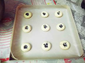 食指沾水，醮上黑芝麻，在饼胚中间戳一个洞，动作要轻。