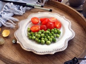 准备辅助食材，把豌豆剥好，小番茄对切。