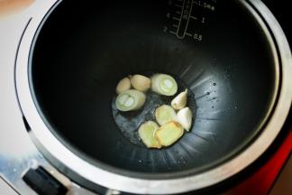 锅里热了之后，加入少许色拉油，一点点就可以，因为鸡皮本身含有油脂，现在的油只要能炒香香料就可以了。先把葱姜蒜放下去炒出香味。