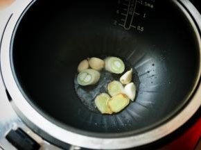 锅里热了之后，加入少许色拉油，一点点就可以，因为鸡皮本身含有油脂，现在的油只要能炒香香料就可以了。先把葱姜蒜放下去炒出香味。