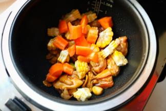 把刚才切好的玉米和胡萝卜放进去，搅拌均匀。胡萝卜里含的是脂溶性维生素，要和肉一起烹调才能有效被人体吸收。而且经过焖炖的胡萝卜口感绵糯也很好吃，就算老人也很容易咬得动。