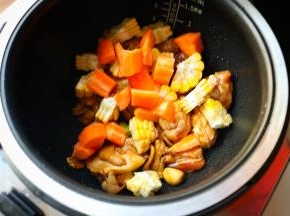 把刚才切好的玉米和胡萝卜放进去，搅拌均匀。胡萝卜里含的是脂溶性维生素，要和肉一起烹调才能有效被人体吸收。而且经过焖炖的胡萝卜口感绵糯也很好吃，就算老人也很容易咬得动。