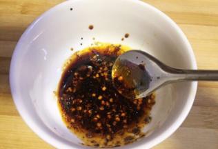 取碗加入少许调味盐，加入一勺生抽和老抽，放入白糖，放入少许五香粉，一勺辣椒油，搅拌均匀