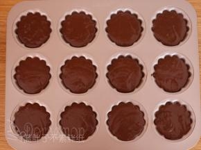 将面糊装进裱花袋，挤到模具中，大约8分满，接着震两下。