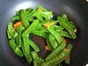 加入荷兰豆和胡萝卜片煸炒。