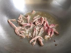 锅内放油烧热，放入肉丝翻炒至变色