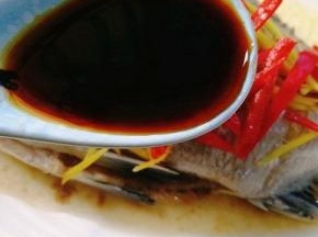 取一勺蒸鱼豉油淋在鱼身上