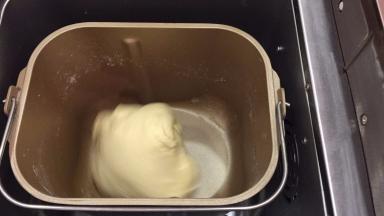 将除黄油以外的所有材料放入面包机桶内，按启动键开始揉面（一个揉面程序剩余5分钟时放入黄油，再启动10分钟）