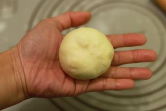 重新取一小份面团，再次轻按排气后收圆