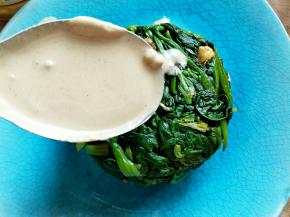 把麻酱和蒜蓉搅拌均匀，浇在菠菜上