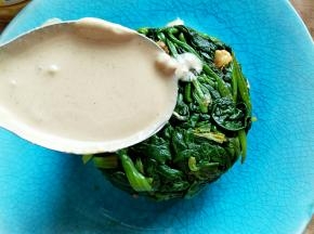 把麻酱和蒜蓉搅拌均匀，浇在菠菜上