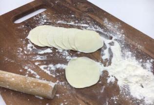 把小圆剂子压平，擀成饺子皮，擀饺子要中间厚，周边薄。