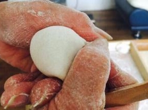 往饺子皮上放适量的饺子馅。先将饺子皮对折，中间捏紧，然后用双手的拇指和食指将饺子皮的边向中间轻轻挤压。