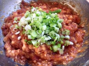 最后放入葱花，在葱花上放约10g左右的香油，先用香油把葱花拌匀，再将葱花与肉馅充分调匀，即朝一个方向搅拌均匀，大约搅拌100下左右。 先用油裹住葱花的目的是防止葱汁外溢，造成肉馅葱味过重。猪肉馅调好了备用。