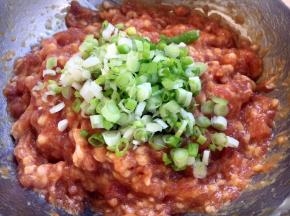 最后放入葱花，在葱花上放约10g左右的香油，先用香油把葱花拌匀，再将葱花与肉馅充分调匀，即朝一个方向搅拌均匀，大约搅拌100下左右。 先用油裹住葱花的目的是防止葱汁外溢，造成肉馅葱味过重。猪肉馅调好了备用。