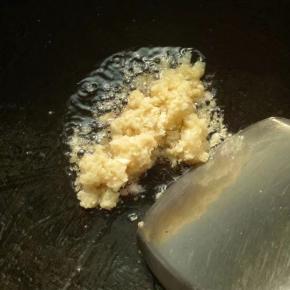 烧锅上放花生油加上剁碎的大蒜和姜爆炒金黄色，记得要开慢火不然会很易焦黑了。