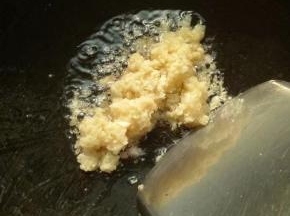 烧锅上放花生油加上剁碎的大蒜和姜爆炒金黄色，记得要开慢火不然会很易焦黑了。