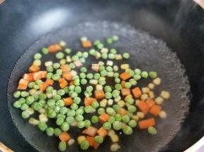 锅中加入水大火烧开，下入豌豆，玉米粒，胡萝卜丁焯水，2分钟捞出淋干水份。
