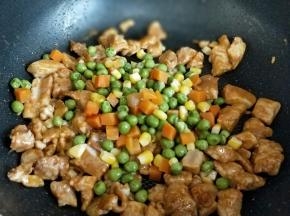 再加入焯水的胡萝卜丁，豌豆，玉米粒煸炒。