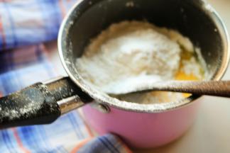 关火后，把低粉筛入黄油牛奶液里，用刮刀翻拌成面团，拌好的面团比较粘稠。