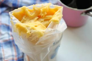 拌好的泡芙面糊放入裱花袋里。裱花袋先固定在杯子里，向外翻开倒入面糊即可。我只有一个人所以要借助杯子，如果有人帮忙那就直接倒入就可以了。