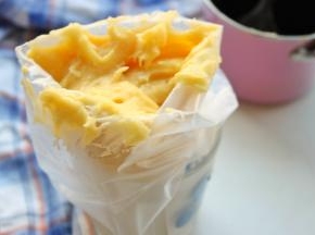 拌好的泡芙面糊放入裱花袋里。裱花袋先固定在杯子里，向外翻开倒入面糊即可。我只有一个人所以要借助杯子，如果有人帮忙那就直接倒入就可以了。