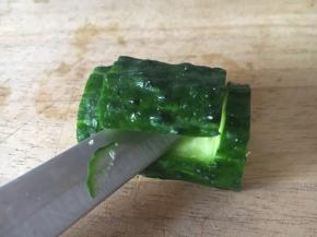 量黄瓜节的底部削平，便于摆放。在黄瓜节的上面用小刀划一个如图所示的长方形，并且用小刀把这片黄瓜翘起来。