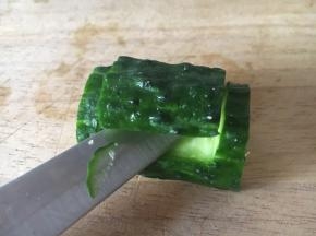 量黄瓜节的底部削平，便于摆放。在黄瓜节的上面用小刀划一个如图所示的长方形，并且用小刀把这片黄瓜翘起来。
