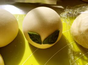 将做好的树叶背部沾点水，装饰在做好的香芋包上