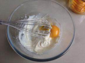 分两次加入蛋黄，每加入一次拌均匀后，再加入下一次