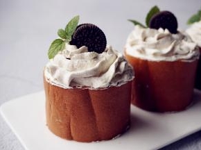 卷起，切成若干等份，切面朝上，挤上淡奶油，放上一块奥利奥饼干和薄荷叶装饰