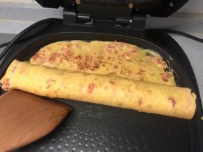 然后用借助木铲把蛋饼卷起。