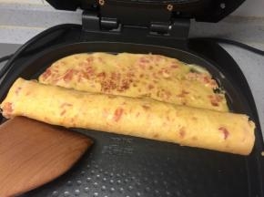 然后用借助木铲把蛋饼卷起。