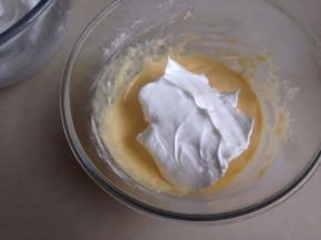 取三分之一打发好的蛋白霜，放入到蛋黄糊里，用刮刀从底部向上翻拌均匀，不要划圈搅拌。